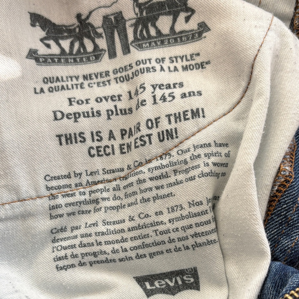 Levi's denim with a bit of distressing above knee and on back pocket.